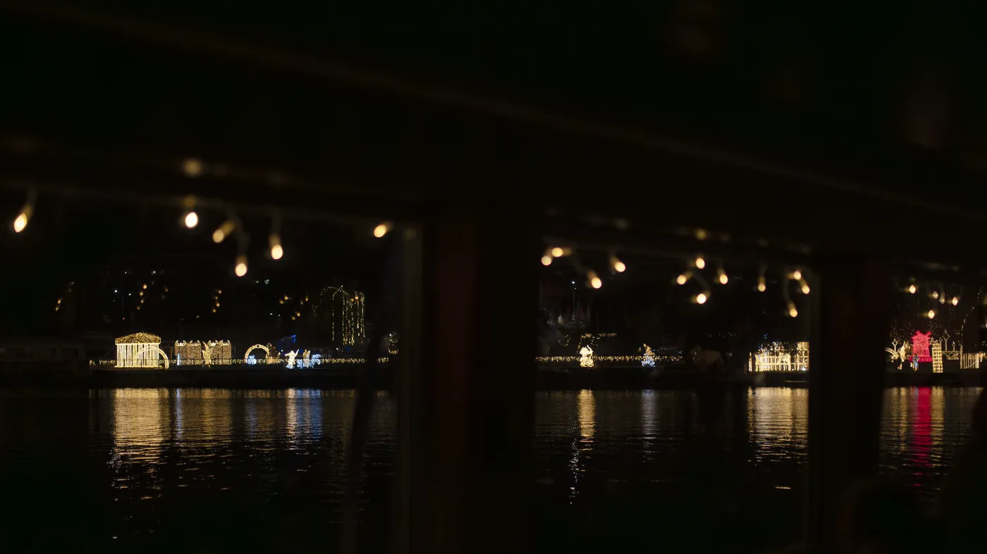 Ein beleuchtetes Ausflugsschiff auf der Moldau am Abend